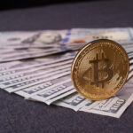 Golden,Metal,Bitcoin,On,Dollar,Bills,Background.,A,Lot,Of